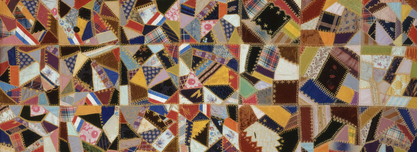 A homemade quilt with jagged pieces and detailed embroidery