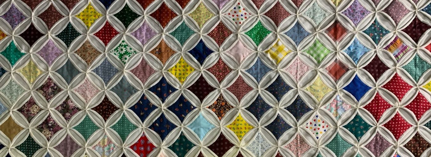 A homemade quilt with diamond-shaped patchwork.