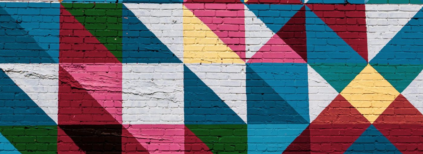 colorful geometric mural on a brick wall